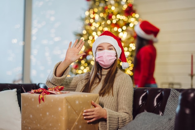 Menina segurando um presente de Natal na véspera de ano novo.