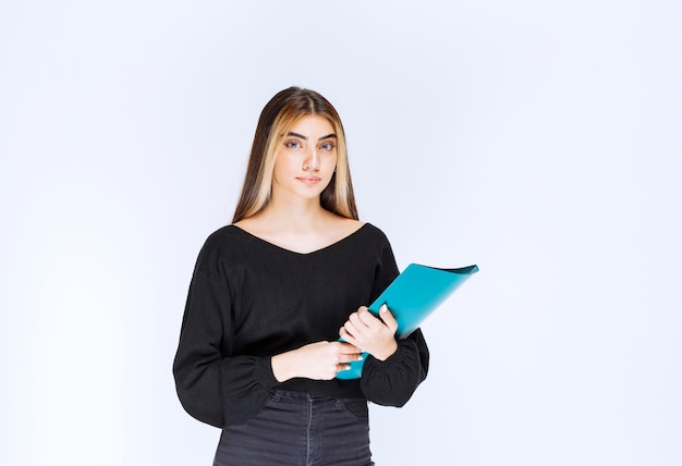 Menina segurando uma pasta de relatório azul. foto de alta qualidade