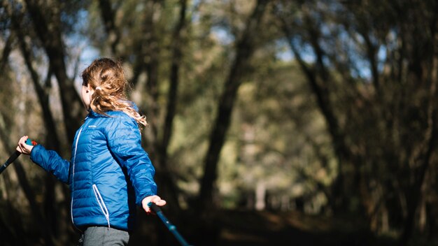 Menina sem rosto andando na floresta