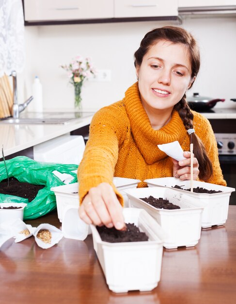 Menina semeando sementes na mesa