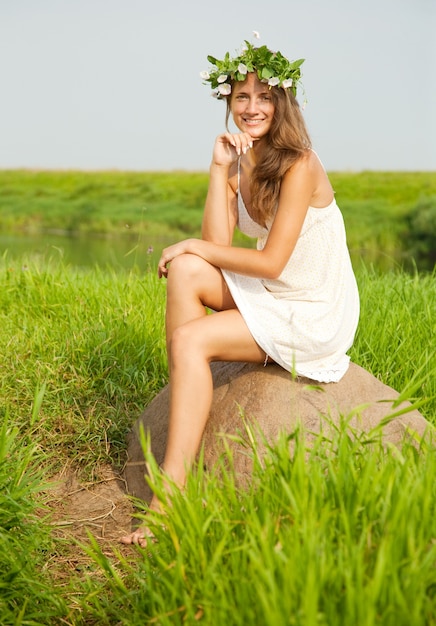Menina sentada na pedra do campo