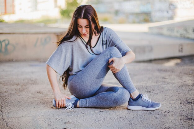 Menina sentada no chão de concreto