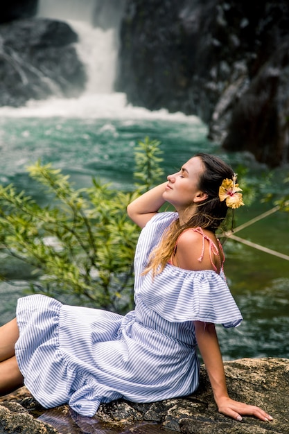 Foto grátis menina sentada perto da cachoeira