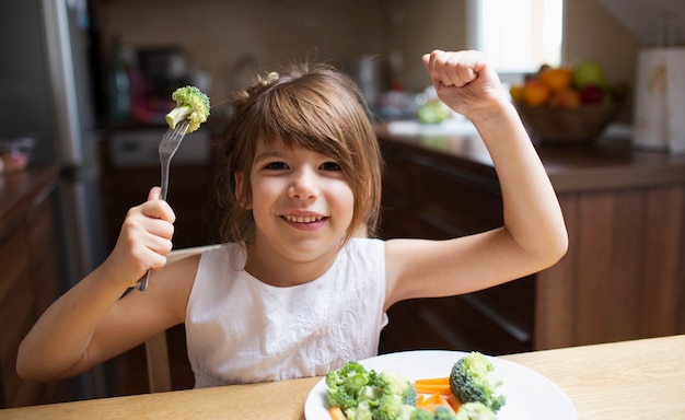 Menina sorridente brincando com comida