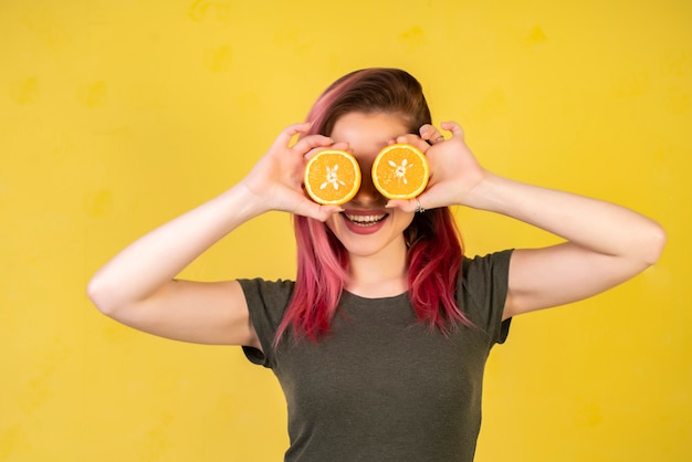 Menina sorridente com fatias de laranja