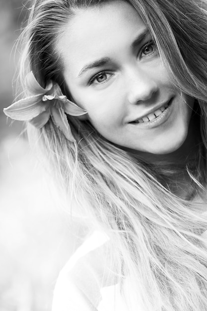 Menina sorridente com flor de lírio no cabelo