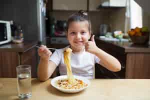 Foto grátis menina sorridente com macarrão no almoço