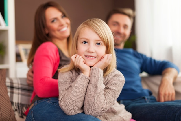 Menina sorridente com os pais em casa