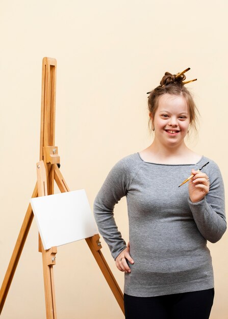 Menina sorridente com síndrome de down, posando com escova