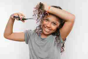 Foto grátis menina sorridente, cortar o cabelo com uma tesoura