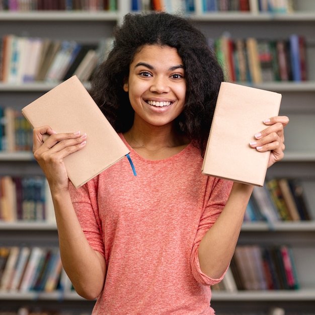 Foto grátis menina sorridente de vista frontal com dois livros