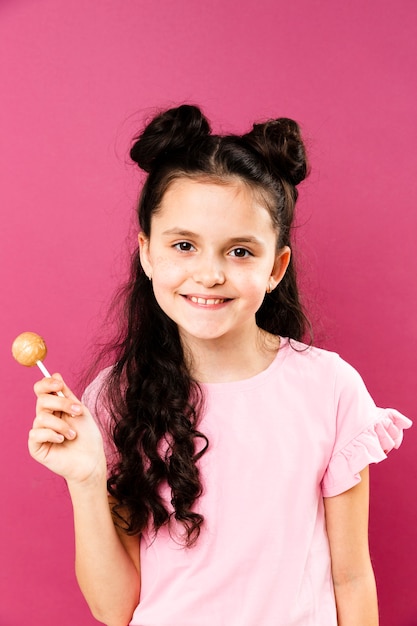 Foto grátis menina sorridente de vista frontal com pirulito