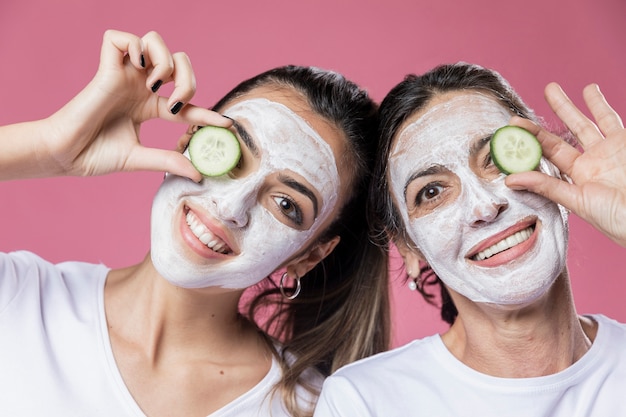 Menina sorridente e mãe com máscara facial