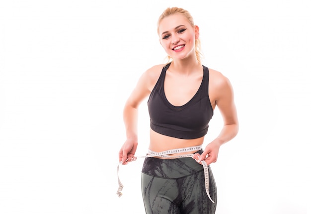 Foto grátis menina sorridente magra segurando o medidor rosa isolado no branco