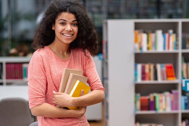 Menina sorridente na biblioteca no dia mundial do livro