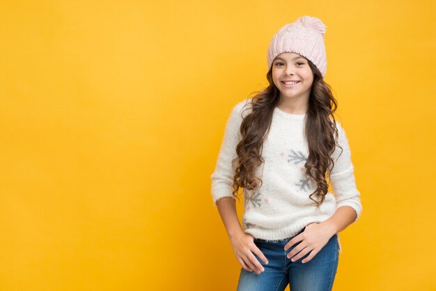 Menina sorridente na camisola com flocos de neve