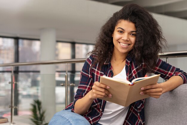 Menina sorridente na leitura do sofá