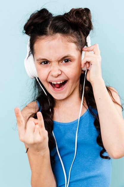 Menina sorridente, ouvindo música rock em fones de ouvido