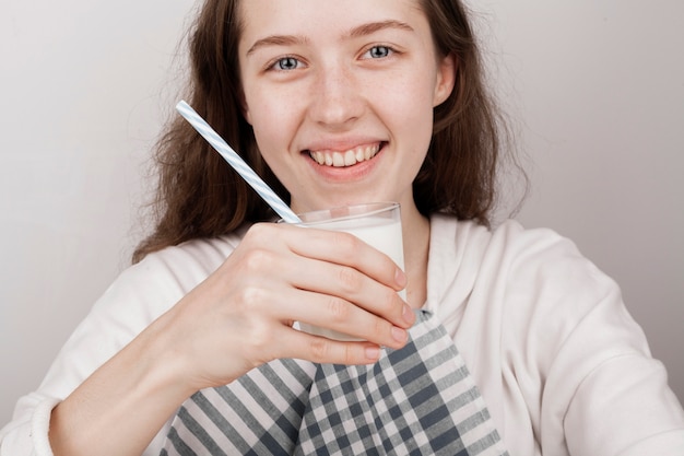 Menina sorridente, segurando um copo de leite