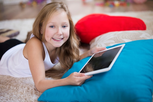 Foto grátis menina sorridente segurando um tablet digital