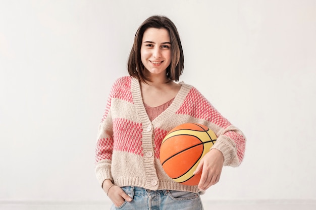 Foto grátis menina sorridente, segurando uma bola de basquete