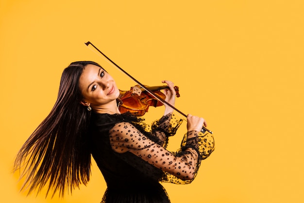 Menina sorridente tocando violino