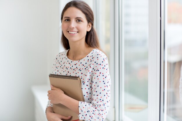 Menina sorrindo com o bloco de notas