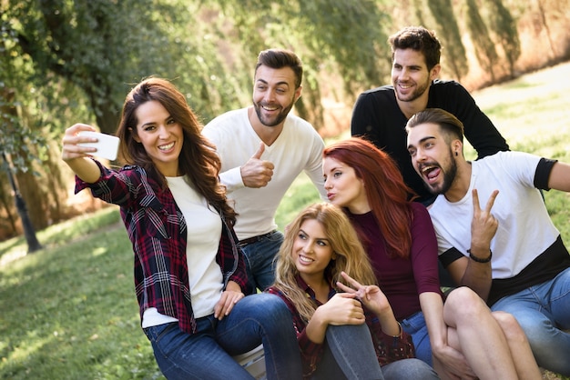 Menina tirando uma foto de si mesma e seus amigos