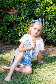 Menina tomando sorvete de chocolate ao ar livre