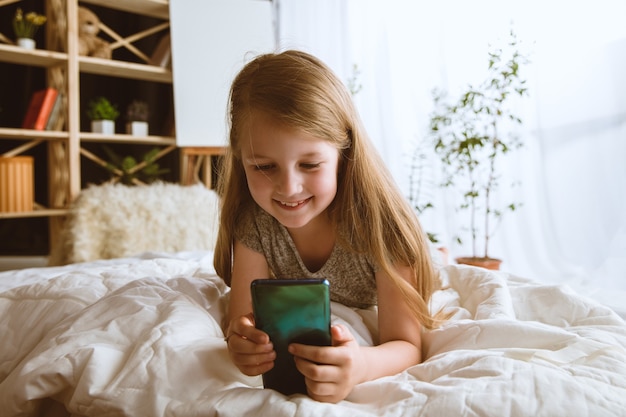 Menina usando diferentes aparelhos em casa