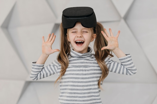 Menina usando fone de ouvido de realidade virtual e sendo feliz