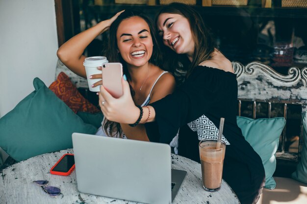 menina usando laptop no café