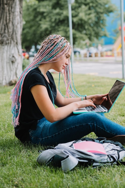 Menina usando laptop no parque