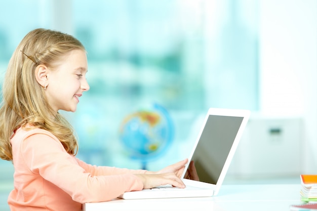 Menina usando o laptop na sala de aula