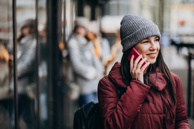 Menina usando telefone fora da rua e encontrar-se com amigos