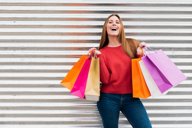 Menina vista frontal segurando sacolas de compras