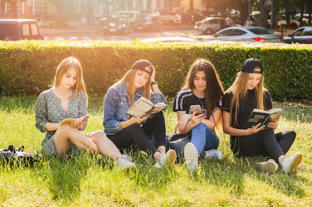 Meninas adolescentes, leitura, livros, e, usando, smartphone