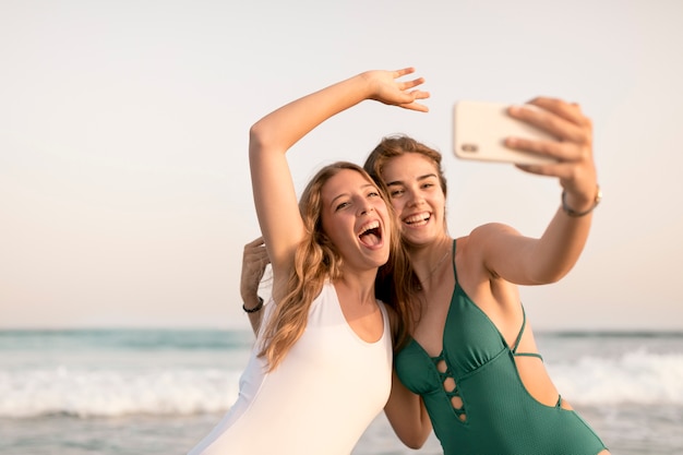 Foto grátis meninas adolescentes, levando, selfie, ligado, telefone móvel, em, praia