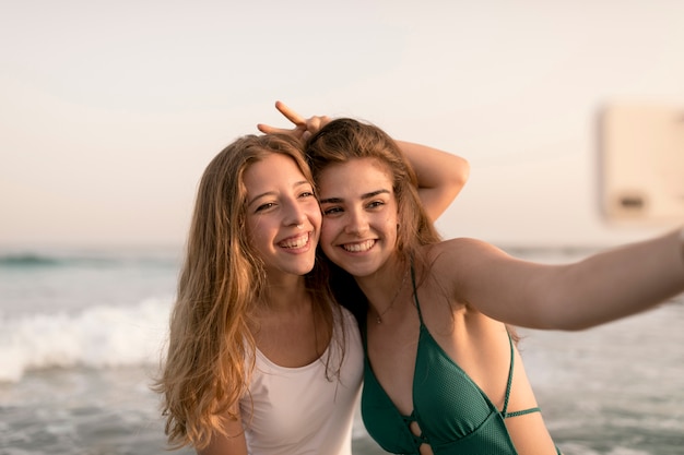 Meninas adolescentes, levando, selfie, ligado, telefone móvel, em, praia