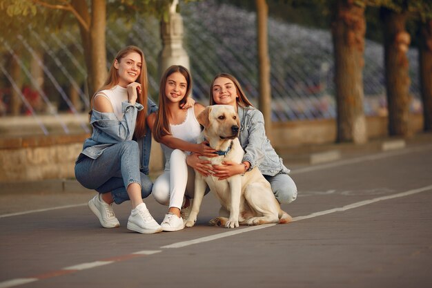 Meninas andando em uma cidade de primavera com cachorro fofo