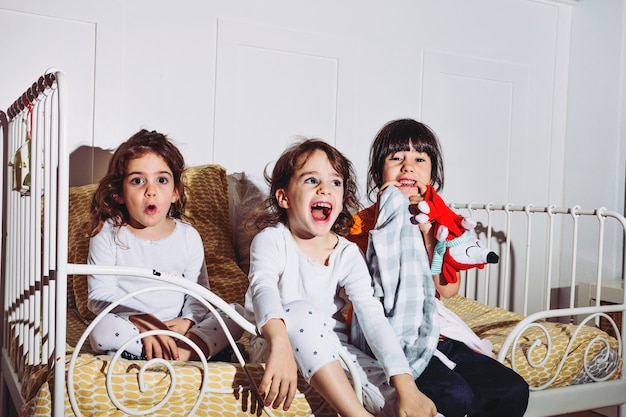 Meninas assustadas em pijamas assistindo tv