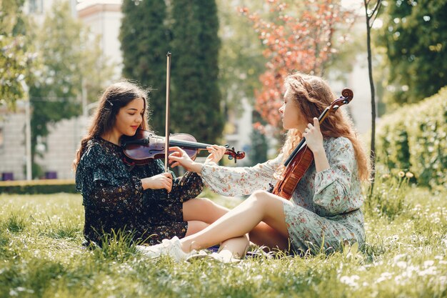 Meninas bonitas e românticas em um parque com um violino