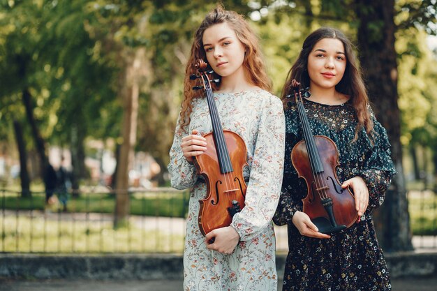 Meninas bonitas e românticas em um parque com um violino