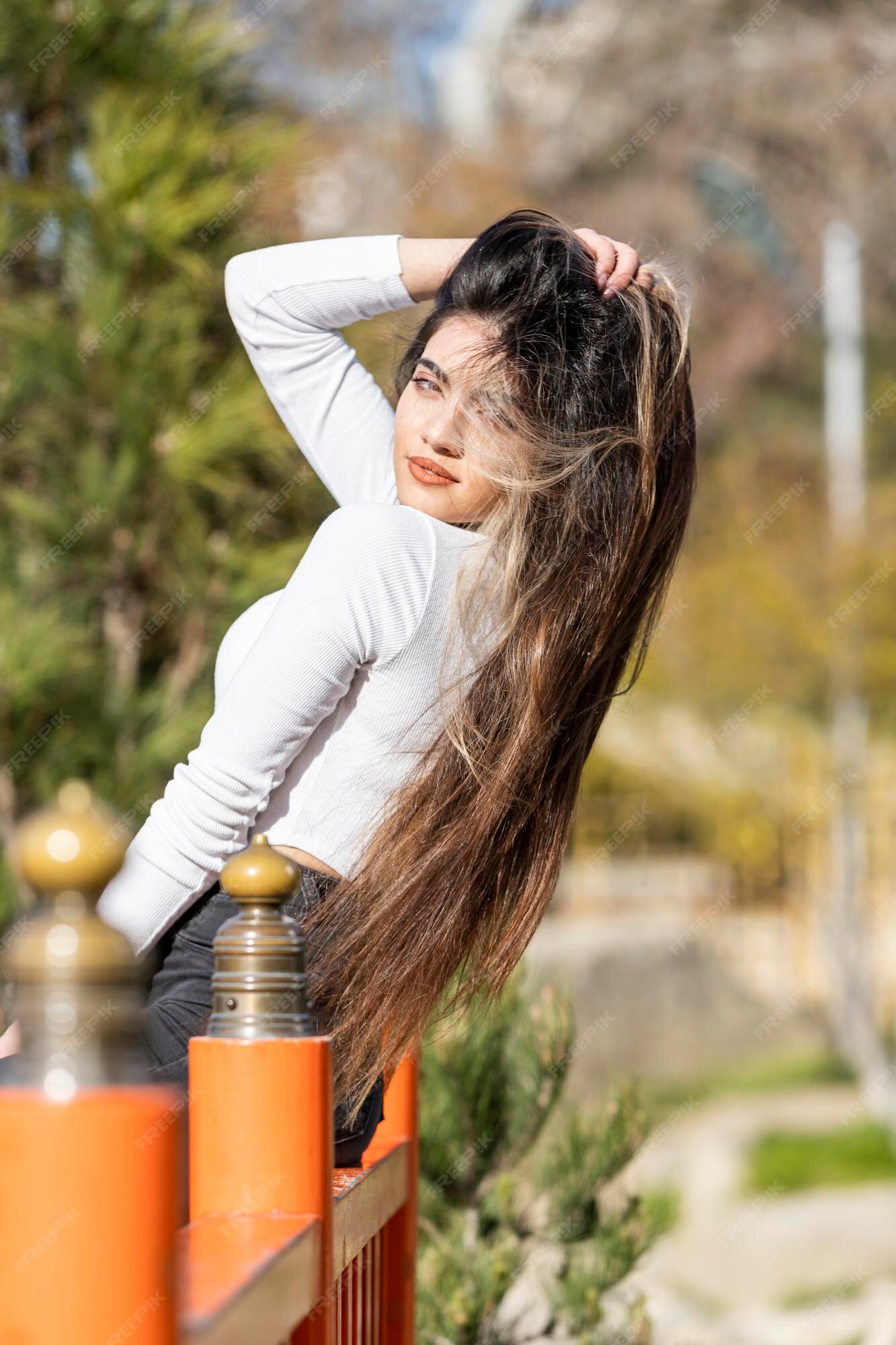 Meninas bonitas esticando o cabelo e olhando para a câmera