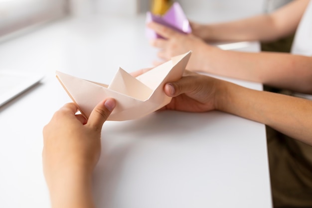 Meninas brincando com papel de origami em casa
