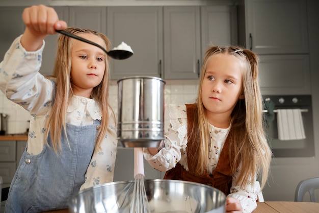 Meninas cozinhando juntas vista frontal