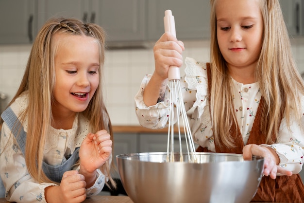 Meninas cozinhando na cozinha plano médio