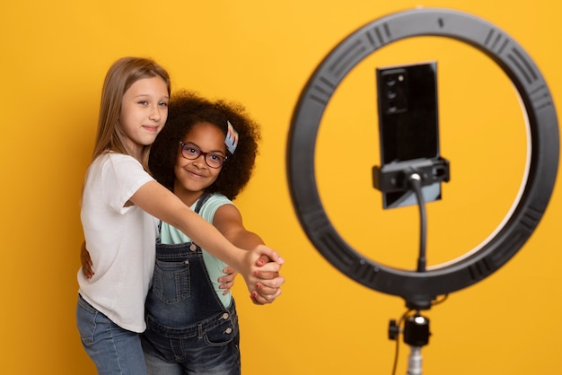 Meninas de tiro médio gravando vídeo