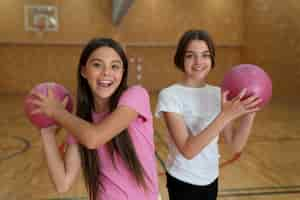 Foto grátis meninas de tiro médio segurando bolas