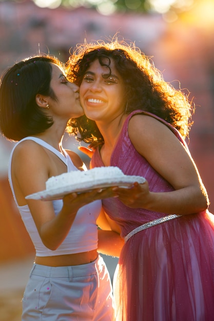 Meninas de tiro médio segurando bolo